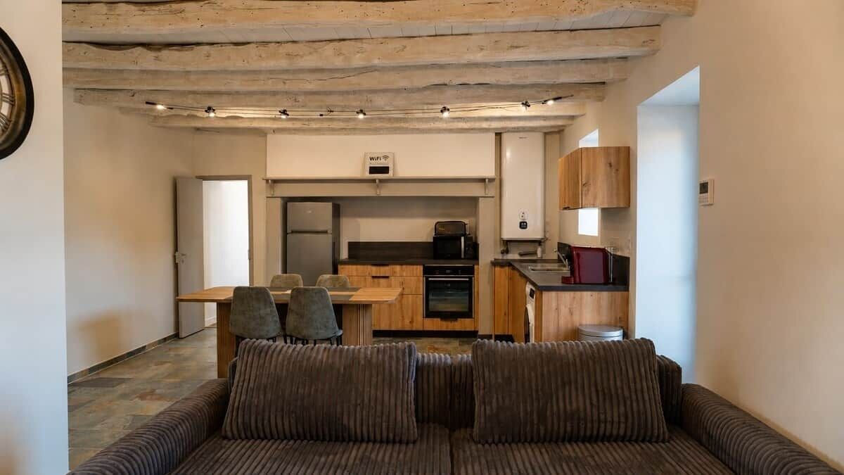 Un espace de vie compact comprenant un canapé, une table à manger et un coin cuisine.
