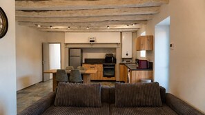 Un espai vital reduït amb sofà, taula de dinar i zona de cuina petit.
