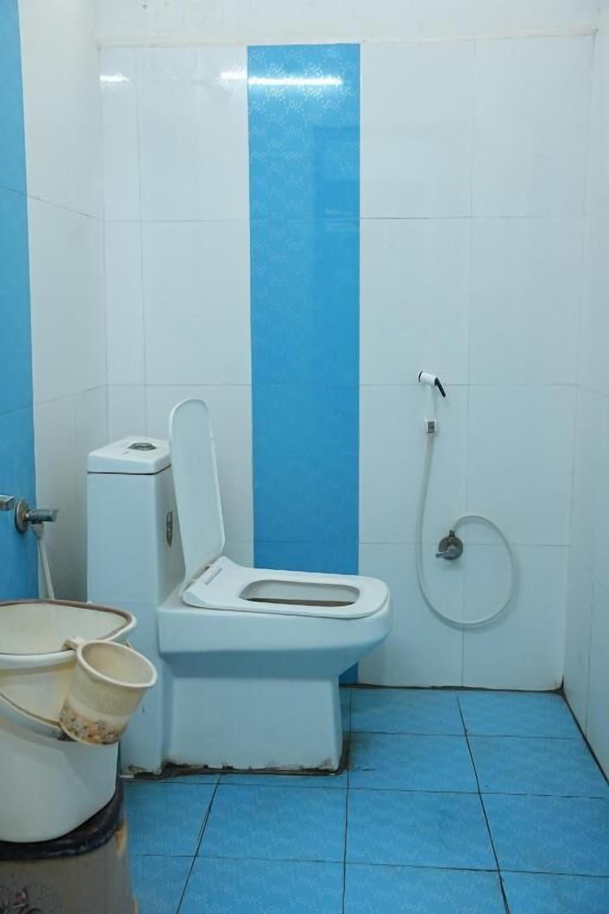A small bathroom with a toilet, bidet, and a trash bin.