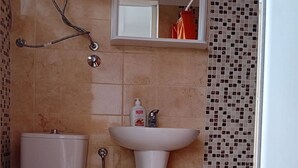 Een badkamer met toilet, wastafel en douche.