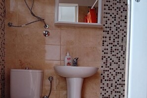 Ein Badezimmer mit Toilette, Waschbecken und Dusche.