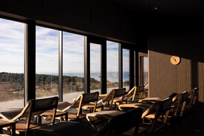A room with large windows, wooden chairs, and a clock on the wall. - Luxury villa within Resort, Savudrija, Umag, Istria (Savudrija)