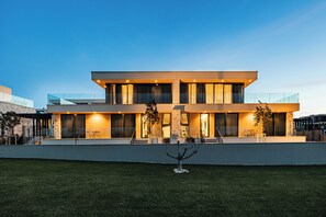 Un bâtiment moderne à deux étages, doté d’un toit plat, de grandes fenêtres et d’une pelouse bien entretenue.