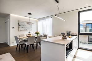 A modern dining area with a central island, chairs, and a table set for a meal. - Luxury villa within Resort, Savudrija, Umag, Istria (Savudrija)