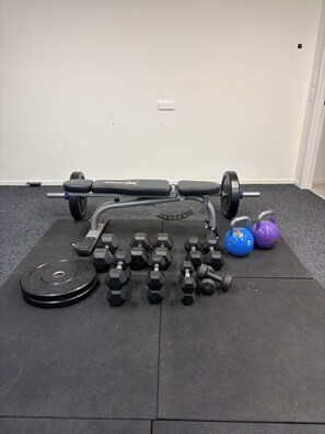 Un banc de musculation avec barres et poids.