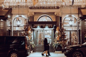 The entrance of Hotel Sacher with a classic facade, ornate decorations, and a prominent sign. - The Story Hotel (Tirana)