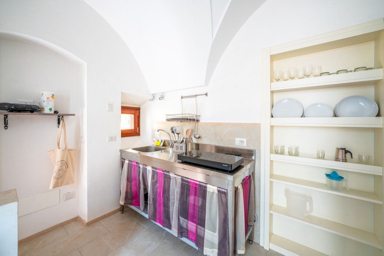 A modern kitchen with a central island, stainless steel appliances, and a white tiled backsplash.