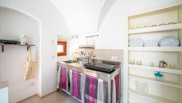 A modern kitchen with a central island, stainless steel appliances, and a white tiled backsplash.