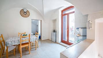 A compact kitchen with a dining area, a small refrigerator, and a window with a view.