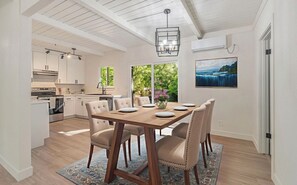 A modern kitchen with white cabinets, a dining area with a wooden table and chairs, and a large window with a view of greenery. - Ultimate Peaceful Country Retreat in Sonora DT (Sonora)
