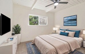 A bedroom with a bed, a TV, a window, a ceiling fan, and a painting. - Ultimate Peaceful Country Retreat in Sonora DT (Sonora)