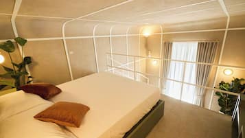 Un dormitorio moderno con una cama litera, una mesita de noche y un ventanal con cortinas.