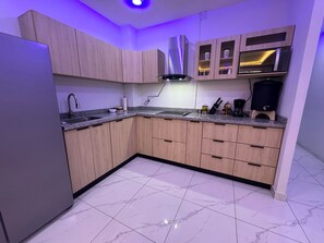 Una cocina moderna con armarios de madera, un refrigerador de acero inoxidable y un horno empotrado.