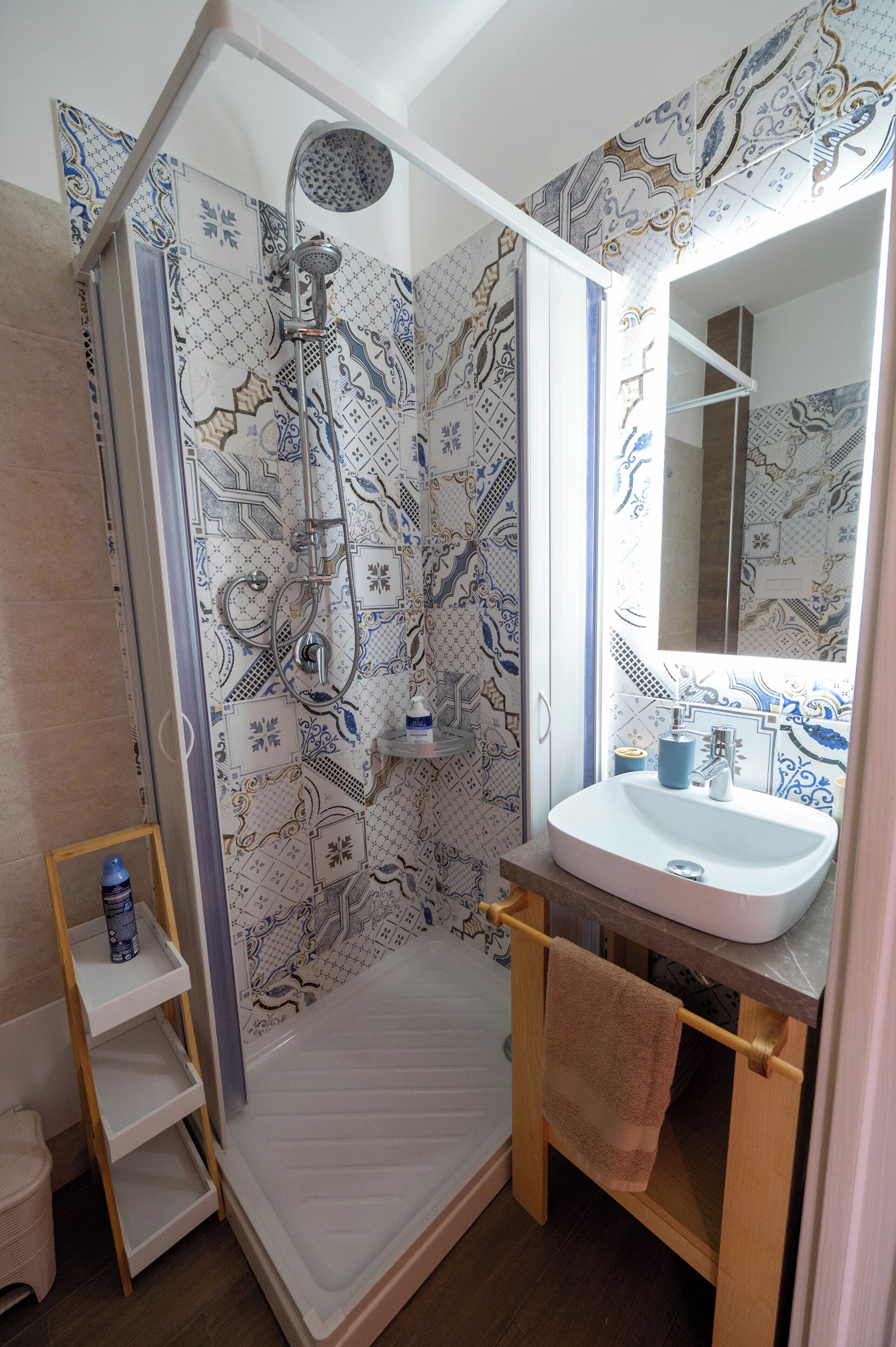 A bathroom with a shower, a sink, and a mirror.