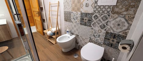 A bathroom with a toilet, bidet, and a shower area.
