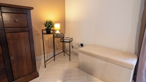 Ein Badezimmer mit einem Holzkabinett, einem kleinen Tisch mit einer Lampe und einer Toilette.