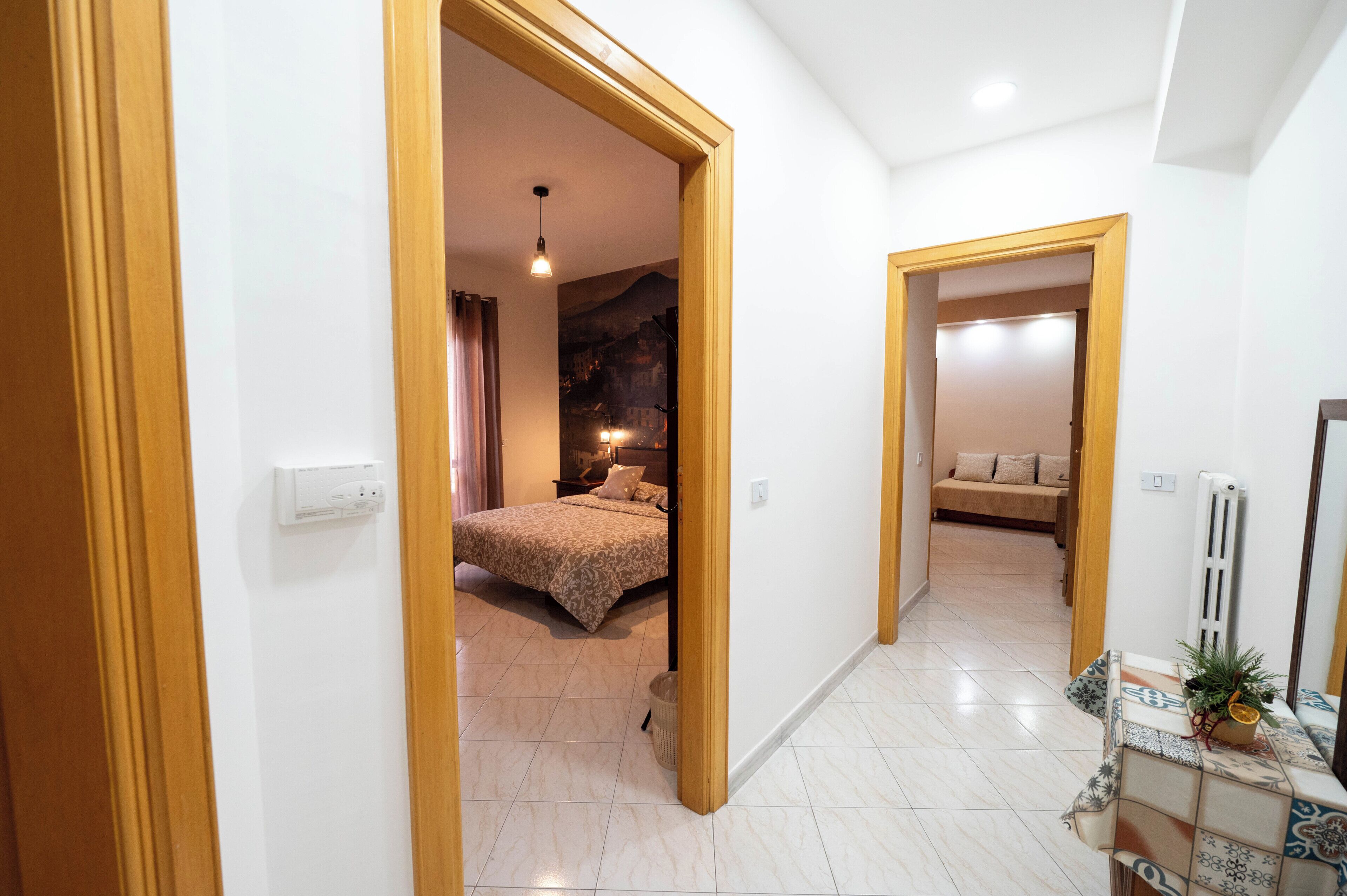A hotel room with a bed, a nightstand, a lamp, and a view of a mountain through the window.