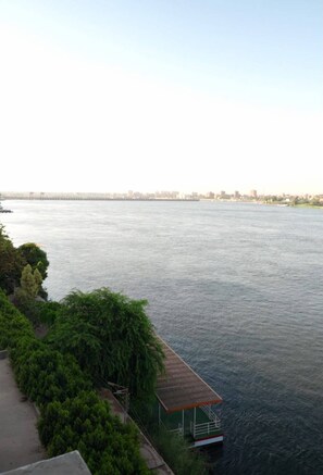 A riverside view with a small dock and a walkway alongside. - Regency Nile Hotel Assuit (Assiut)