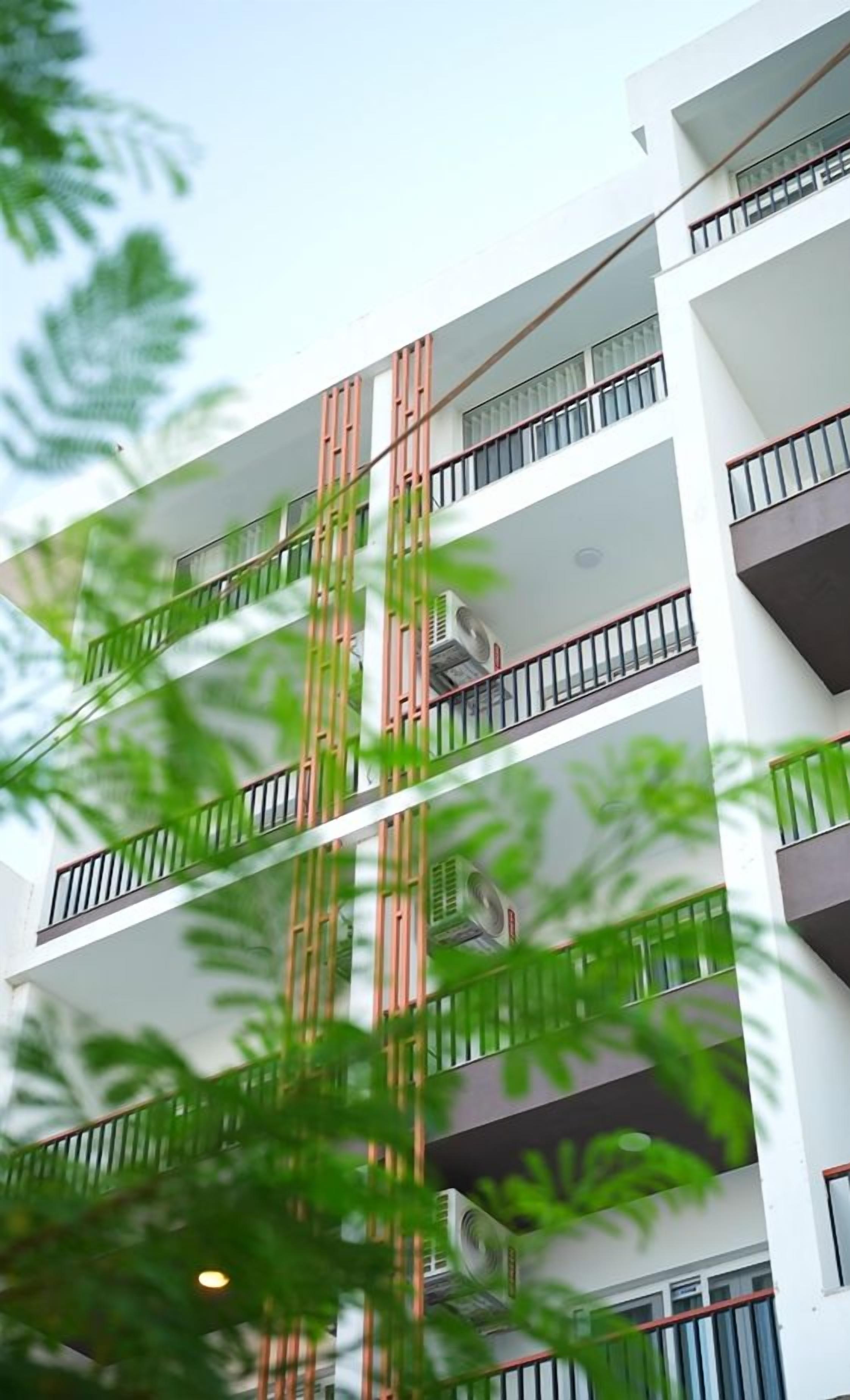 A multi-story building with balconies and air conditioning units.
