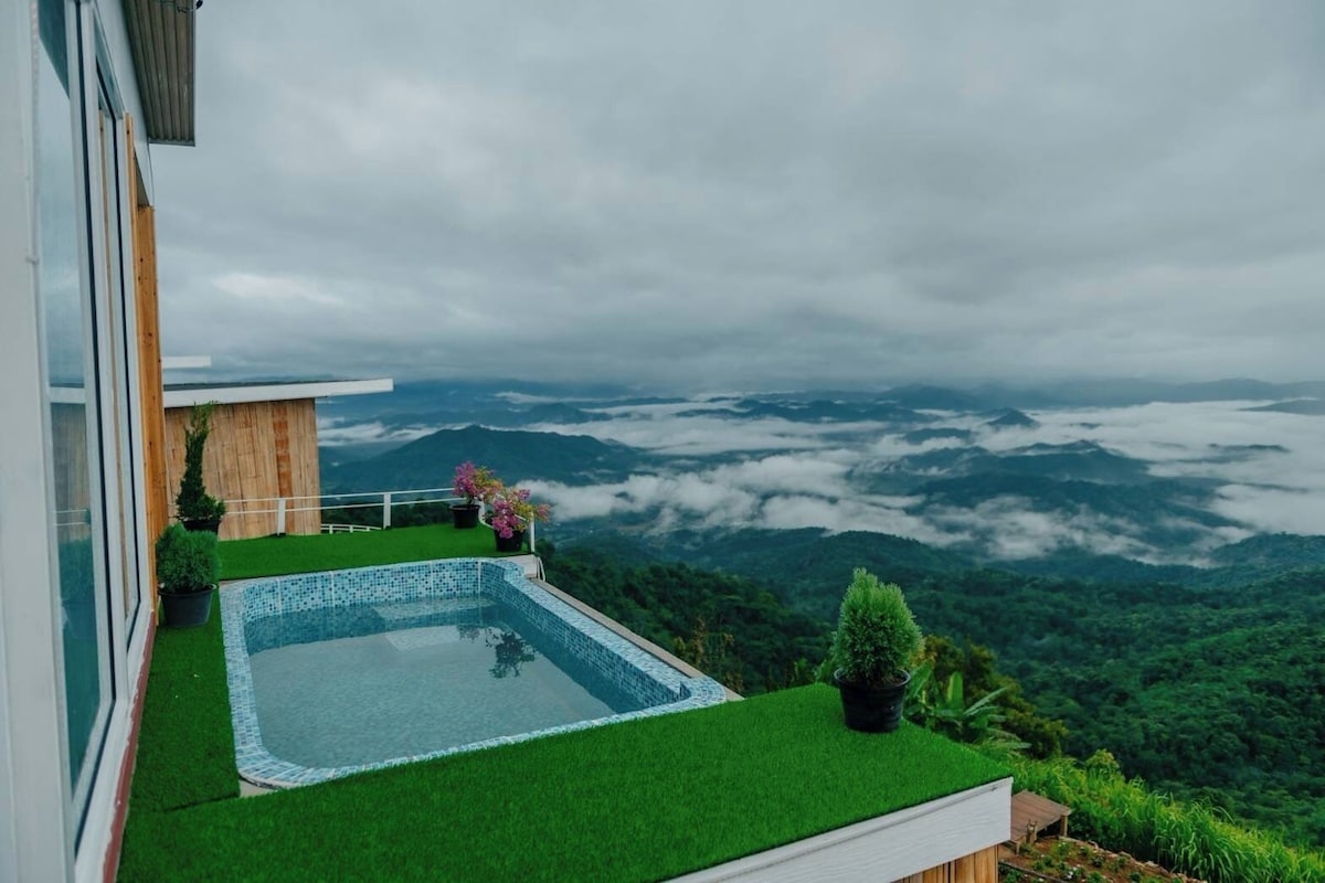 A rooftop pool with a view of a mountainous landscape.