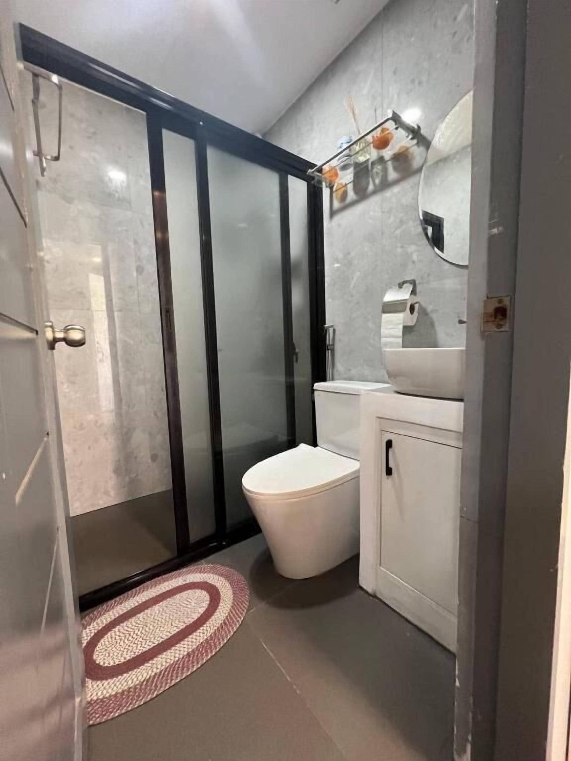Ein Badezimmer mit Duschkabine, Toilette, Waschbecken und Spiegel.
