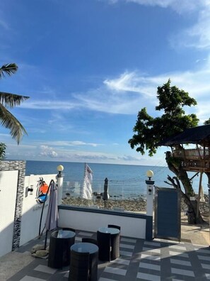 A terrace with a view of the sea, a wooden deck, and a seating area.