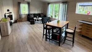 Un salon moderne avec un canapé, une table à manger et une cheminée.