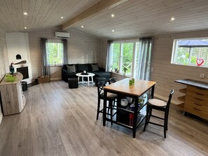 Ein modernes Wohnzimmer mit einer Couch, einem Esstisch und einem Kamin.