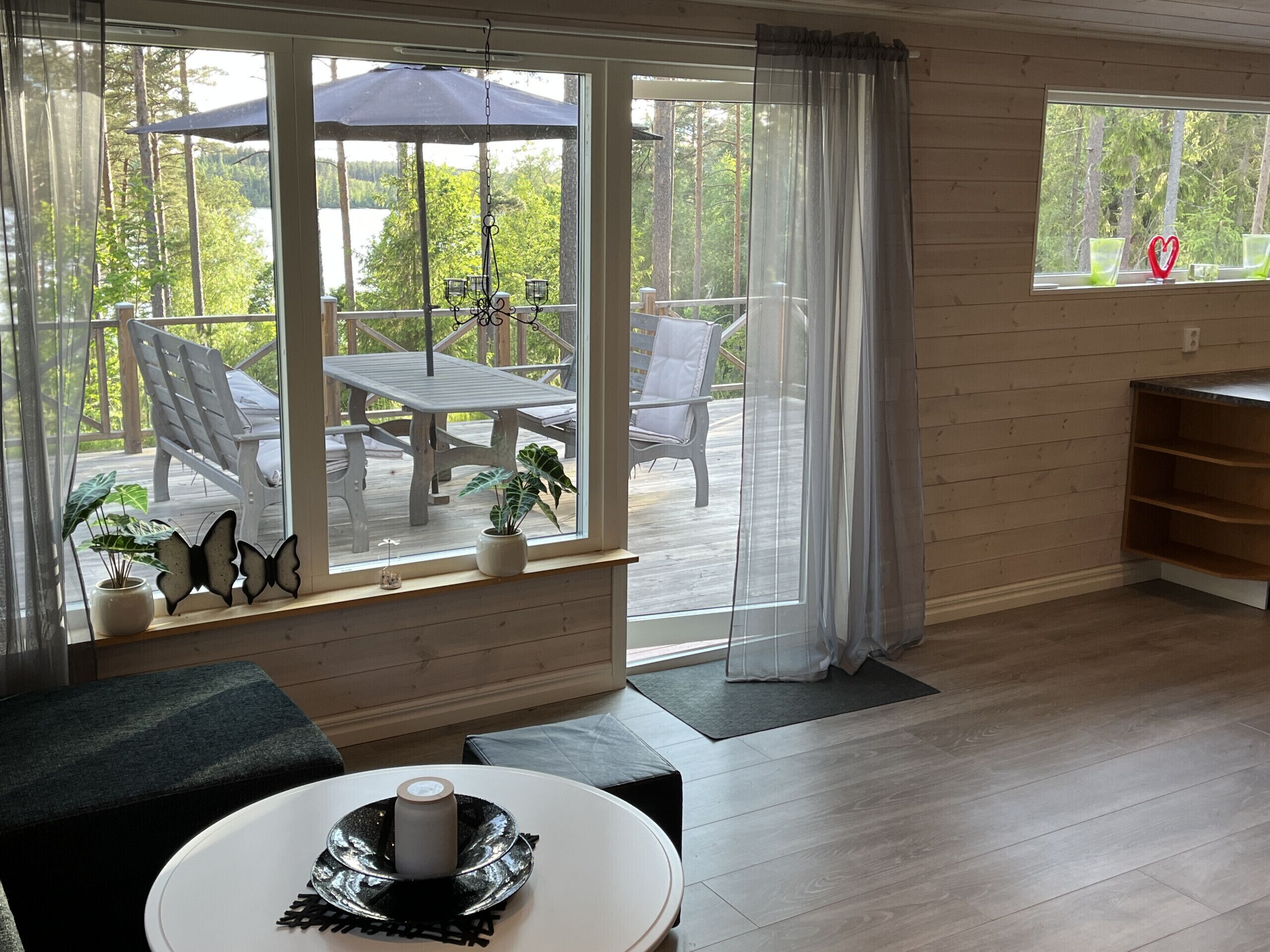 Una habitación con un ventanal grande, una mesa de comedor y una zona de estar con sillas.