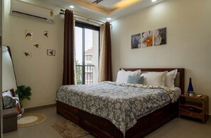 Un dormitorio con una cama grande, una mesita de noche, un espejo y una ventana con cortinas.