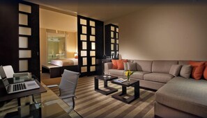 A modern hotel room with a glass desk, a sofa, a coffee table, and a bed with a glass shower enclosure. - Northwest Deluxe Suite w/ Pool Access & Free Shuttle | 5-Min to MIA Airport (Miami Springs)