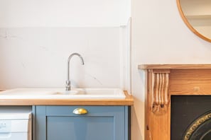 Un baño con lavamanos, un armario de madera y un espejo.