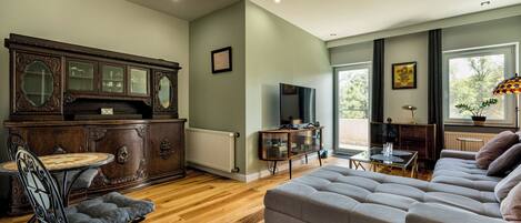 Una sala de estar con un mueble de madera, un televisor, un sofá y una mesa de comedor.