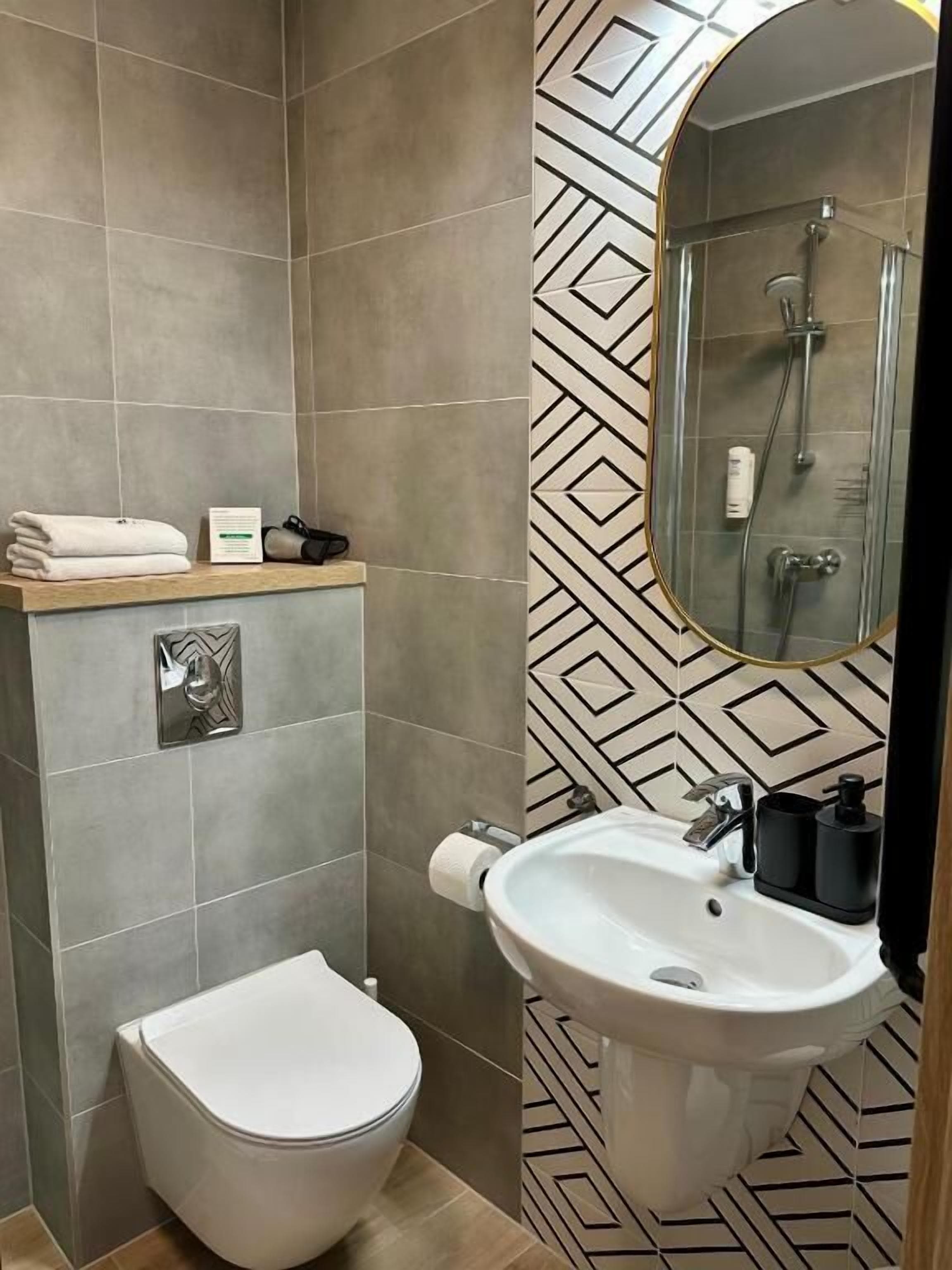 A bathroom with a toilet, sink, and shower.