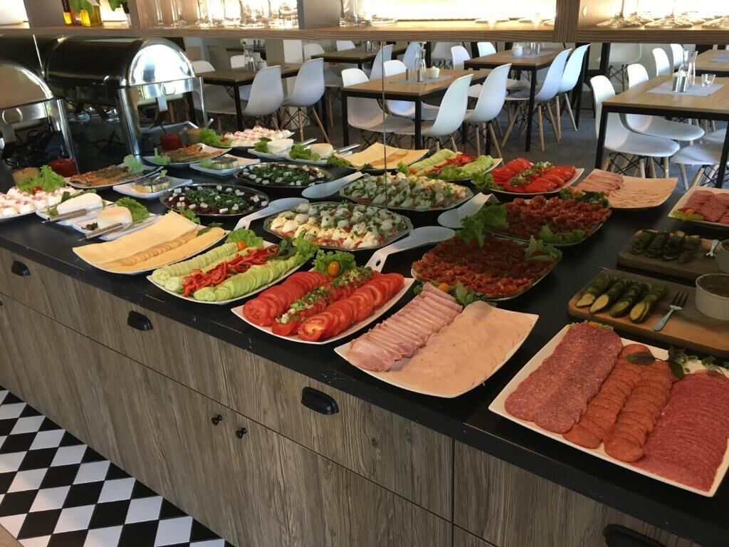 A buffet with various food options including salads, meats, and vegetables.
