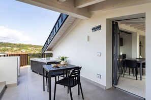 A balcony with a table, chairs, and a potted plant. - Casa Valtenesi - 3 Sensi (Puegnago sul Garda)