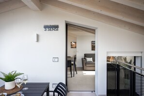 A modern interior with a dining area, a sofa, and a staircase.