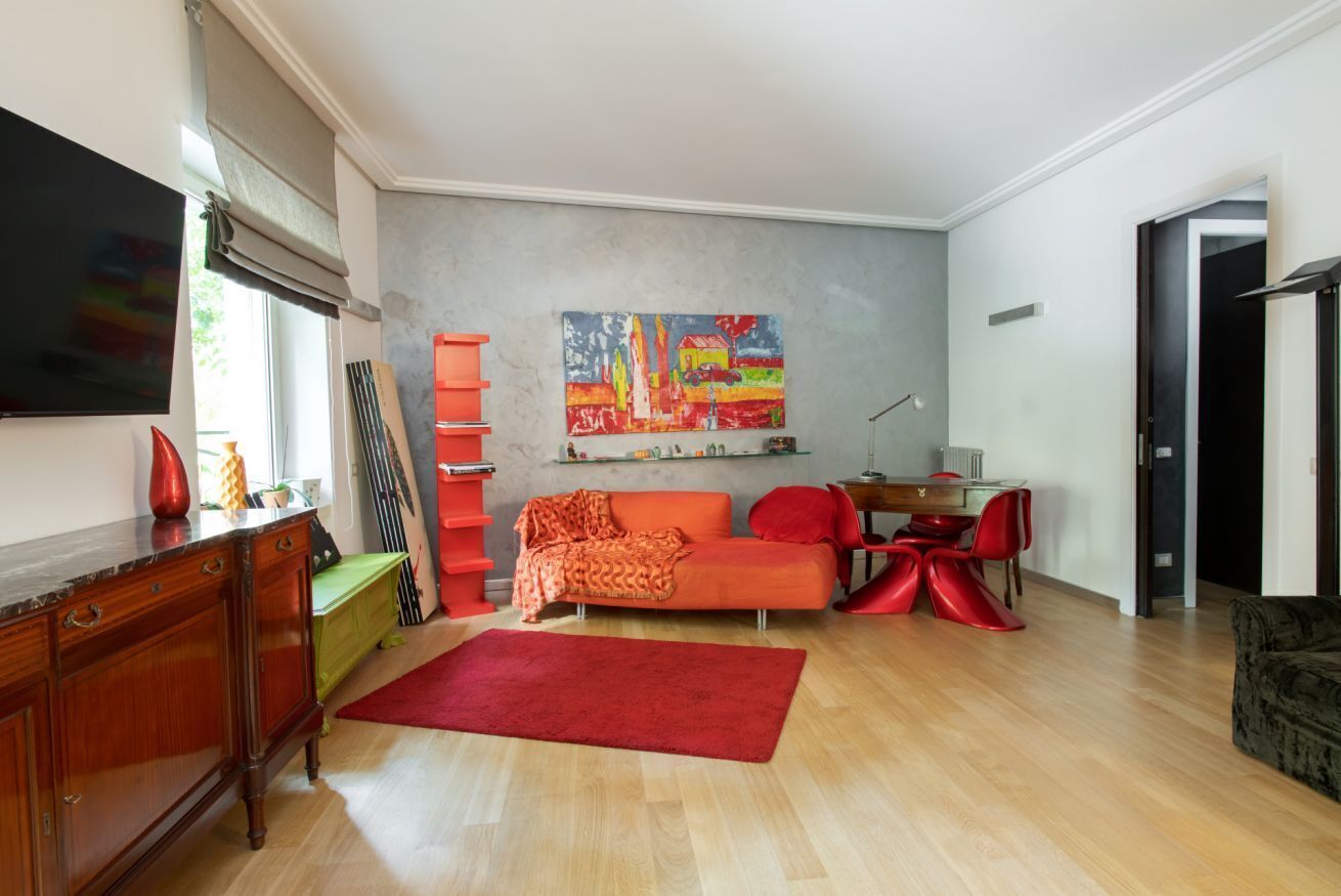 Una sala de estar con un sofá, una mesa de centro, un televisor y un cuadro en la pared.