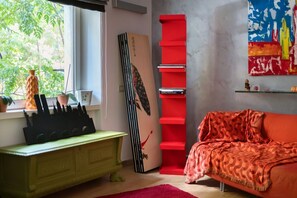 A room with a window, a bookshelf, a sofa, and a decorative wall piece. - Quasi per casa By Dimorra (Naples)
