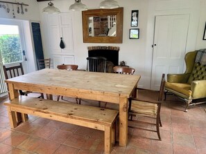Ein Holzespeisesaal mit Bänken, einem Kamin und einem gelben Sessel in einem Raum mit Fliesenboden.