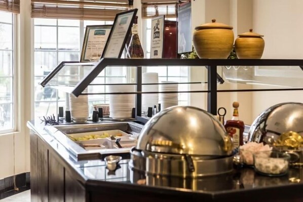 A buffet area with a glass display case, a menu sign, and decorative items.