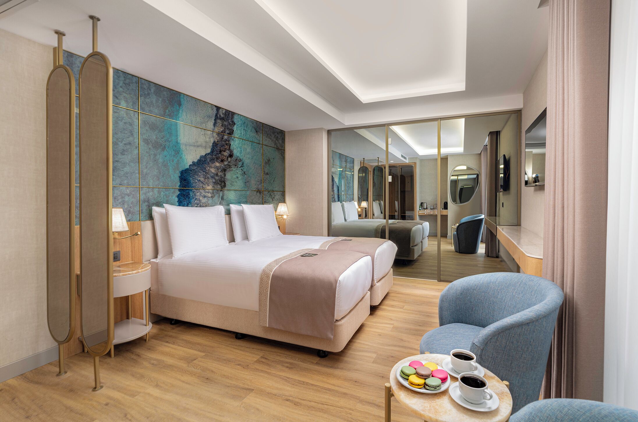 A hotel room with a large bed, a seating area with a table, and a mirror.