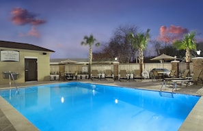 A swimming pool with lounge chairs and umbrellas, a lifeguard station, and palm trees. - Accessible 2BR Suite | Free Daily Breakfast + Pool (Houston)