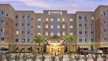 Ein Staybridge Suites Hotel mit zentralem Eingang, mehreren Etagen und einem Parkplatz.