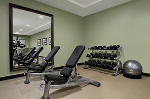 A gym with weight benches, dumbbells, and an exercise ball. - Accessible Queen Studio w/ Free Breakfast + Pool (Houston)