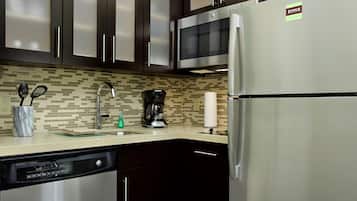 A modern kitchen with stainless steel appliances, a coffee maker, and a dishwasher.