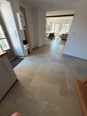 A hallway with a tiled floor leading to a dining area with chairs and a table. - Stone house with a hot tub - 4 bedrooms - 800 m from the beach - Batz-sur-Mer (Batz-sur-Mer)