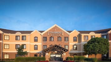 Een Staybridge Suites hotel met een symmetrische gevel, veel ramen en een centrale ingang met een decoratieve boog.