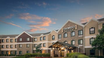 A multi-story hotel with a stone facade and a covered entrance.