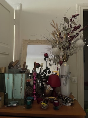 A room with a wooden table, a mirror, and various decorative items including a vase with dried plants and flowers. - Bed room in a cosy appartement Eiffel Tower (Paris)